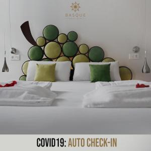 1 dormitorio con 2 camas y almohadas verdes y blancas en Pensión Basque Boutique, en Bilbao