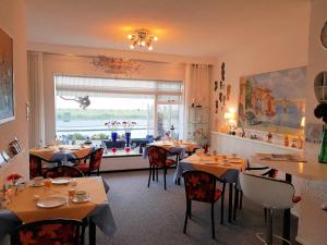 un ristorante con tavoli e sedie e una finestra di Hotel B&B Seahorse a Katwijk
