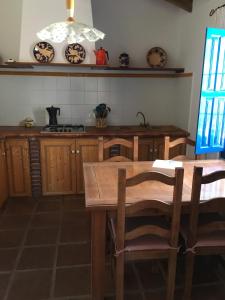 una cucina con armadi in legno e tavolo con sedie di Casa Los Ruices a Benajarafe