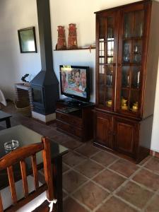 un soggiorno con TV e un centro di intrattenimento di Casa Los Ruices a Benajarafe