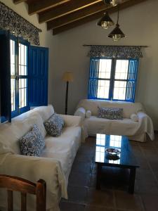 un soggiorno con divani bianchi e finestre blu di Casa Los Ruices a Benajarafe