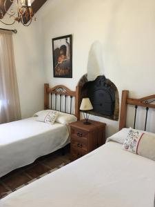 een slaapkamer met 2 bedden en een klok aan de muur bij Casa Los Ruices in Benajarafe