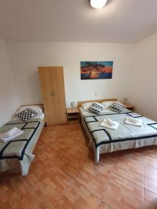 1 dormitorio con 2 camas y suelo de madera en Villa Brasina, en Mlini