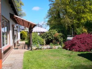 a house with a yard with flowers and a pathway at Künstler Ferienwohnung 3 Zimmer Küche Bad zentrale Lage in Wulsbüttel