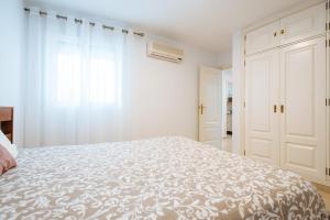 Habitación blanca con cama y ventana en Hostly Lagar Center-Fibre-Parking optional-CLess en Sevilla