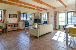 uma sala de estar com um sofá e uma mesa em vakantiehuis op terschelling em Baaiduinen