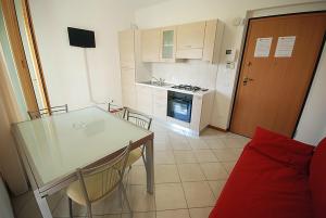 een keuken met een tafel en stoelen en een fornuis bij Residence Seaside in Tortoreto Lido