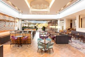 a restaurant with tables and chairs and a chandelier at Crowne Plaza Reading in Reading