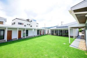 an empty courtyard of a building with a green lawn at Le.Blanche in Minamiawaji