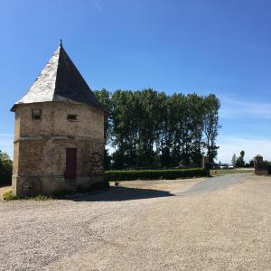 un pequeño edificio de piedra al lado de una carretera en Chambres dhotes a la ferme, en Forest-Montiers