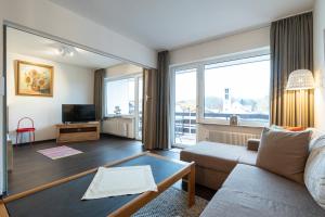 a living room with a couch and a large window at Ferienwohnung Schmid in Oberstdorf