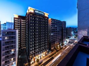 a tall building with a sign on the top of it at APA Hotel Shin Osaka Ekimae in Osaka