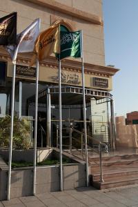 a restaurant with two flags in front of a building at Lavande Suites in Yanbu