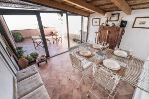 une table et des chaises dans une chambre avec une grande fenêtre dans l'établissement Tra mari e TraMonti - Casa per 6 con terrazza panoramica, à Cuglieri