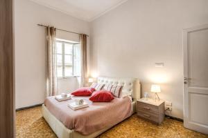 a bedroom with a large bed with red pillows at Colonna Suite - Rome Termini Station Big Apartment in Rome