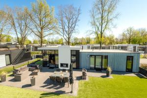 ein modernes Haus mit einer Terrasse und einem Hof in der Unterkunft Cube Exclusive Plus mit Meerblick am Strand im EuroParcs Bad Hoophuizen in Hulshorst