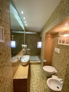 a bathroom with a sink, toilet and bathtub at La Via della Giudecca in Syracuse