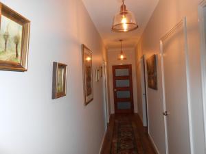 a hallway with a door and paintings on the walls at Lakeview in Bridgetown