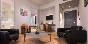 a living room with black chairs and a table at Hotel The Cube in Fidenza