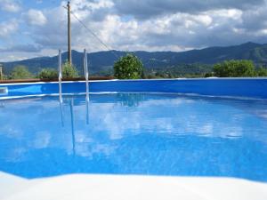 a large blue swimming pool with mountains in the background at Casa Vacanze Lillo in Vezzano Ligure
