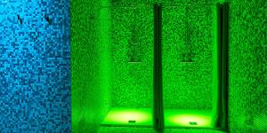 a green room with a window with a green light at Hotel The Cube in Fidenza