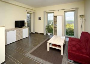 uma sala de estar com um sofá vermelho e uma mesa em Hotel und Restaurant Rittergut Kreipitzsch em Naumburg