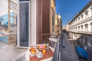 una mesa con un plato de comida en el balcón en B&B DolceVita Napoli, en Nápoles