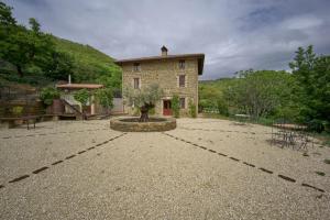 a building with a tree in the middle of a courtyard at Incantico "Eco Resort" in Assisi