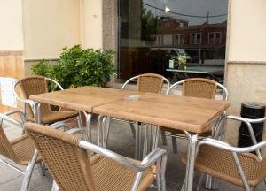 een houten tafel en stoelen op een patio bij Hostal Casa Jose in Santa Cruz