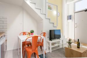 - un salon avec une table et des chaises orange dans l'établissement Relax in this funky loft next to metro!, à Athènes