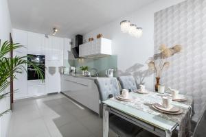 a kitchen with a table and chairs in a room at Apartamenty Latarnia Morska – Sun Seasons 24 in Kołobrzeg