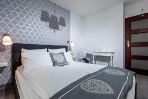 a bedroom with a bed with a blue and white comforter at Apartamenty Latarnia Morska – Sun Seasons 24 in Kołobrzeg