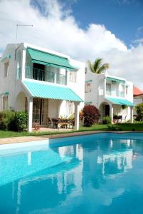 a house and a swimming pool in front of a house at Spacious House in Flic en Flac with Shared Pool in Flic-en-Flac
