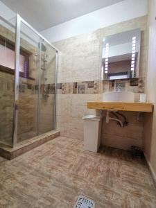 a bathroom with a sink and a shower at Cappuccino Apartment-Brilliant Apartments in Constanţa