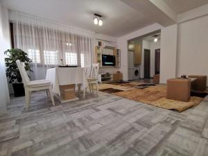 sala de estar con mesa blanca y sillas en Cappuccino Apartment-Brilliant Apartments en Constanza