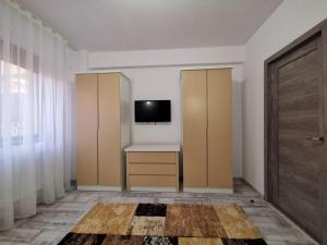 Habitación con escritorio y TV en la pared. en Cappuccino Apartment-Brilliant Apartments en Constanza