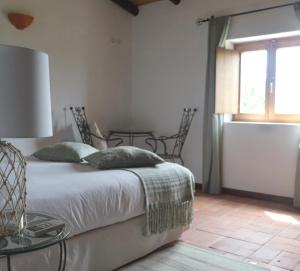 een slaapkamer met een bed met een glazen tafel en een raam bij Quinta Do Mel in Albufeira