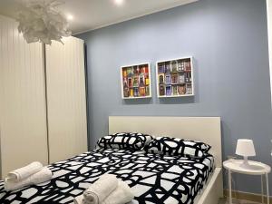a bedroom with a bed with black and white sheets at Appartamento D & D in Niscemi