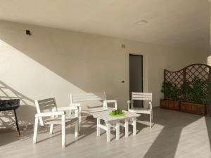 a room with white furniture and a table and chairs at Appartamento D & D in Niscemi