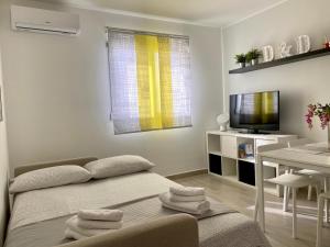 a room with a bed and a table and a television at Appartamento D & D in Niscemi