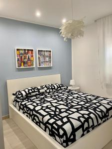 a bedroom with a bed with a black and white comforter at Appartamento D & D in Niscemi
