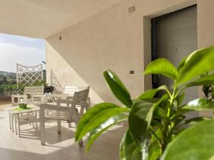 a patio with chairs and tables and a plant at Appartamento D & D in Niscemi