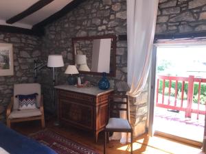 1 dormitorio con espejo y pared de piedra en Chambres d'hôtes GELA ITSASOA Baie, en Ciboure