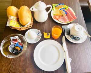 uma mesa com pratos de comida e um jarro de sumo de laranja em Pension Am Pollingpark em Dessau