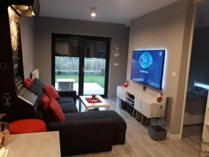 a living room with a couch and a flat screen tv at Apartament LUCKY 7 Gardenia Seaside in Dziwnów