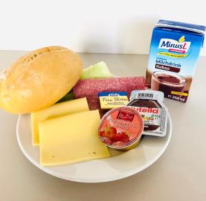 eine Platte mit Käse und anderen Lebensmitteln auf dem Tisch in der Unterkunft Pension Am Pollingpark in Dessau