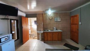 Genesis Self Catering Apartments في بلومفونتين: حمام مع حوض ومرحاض