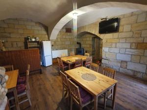 a room with wooden tables and chairs and a refrigerator at Chalupa Vesec in Vesec