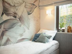sypialnia z malowidłem kwiatowym na ścianie w obiekcie Apartament Nadmorski z ogródkiem i sauną w mieście Mechelinki