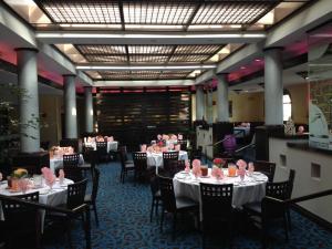 une salle à manger avec des tables et des chaises et des roses roses sur elles dans l'établissement DoubleTree by Hilton Chatsworth, à Chatsworth